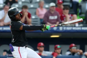 Tre Phelps, da Geórgia, é expulso pelo técnico Wes Johnson após comemorar o home run na vitória regional sobre o Liberty
